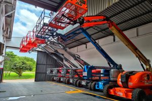 A imagem mostra plataformas elevatórias disponíveis em uma empresa de locação de equipamentos.